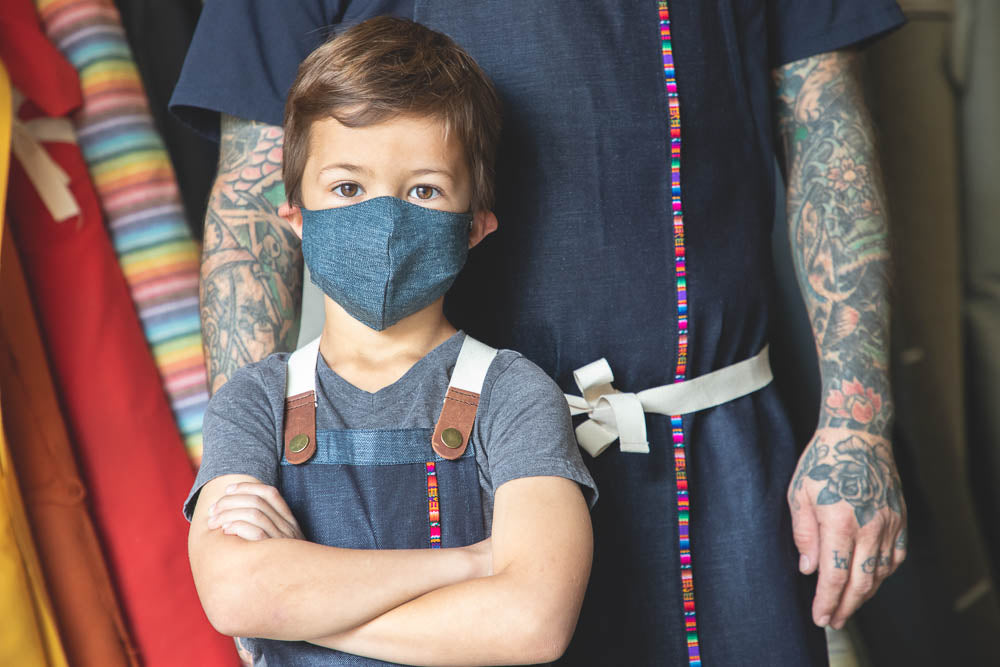 Child wearing kids blue Adkerfeldt apron 