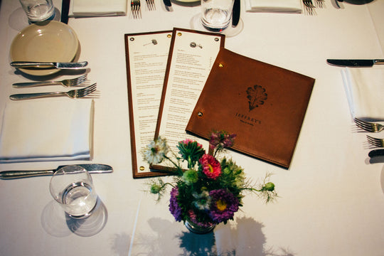 Laser engraved leather menus at a fine restaurant table