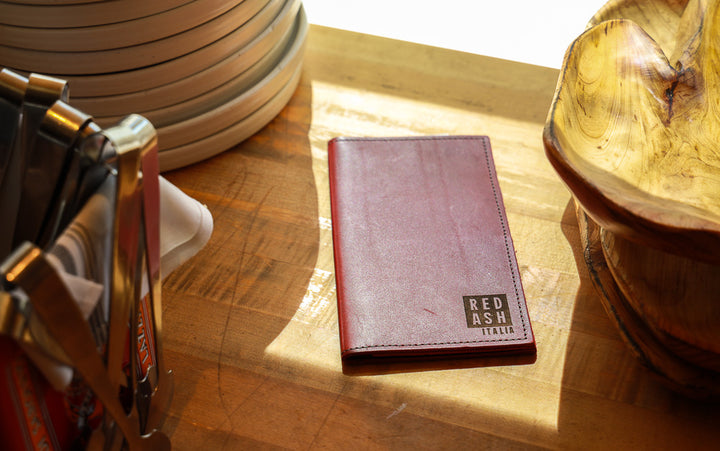 Custom leather Red Ash check presenter in a sunny restaurant spot