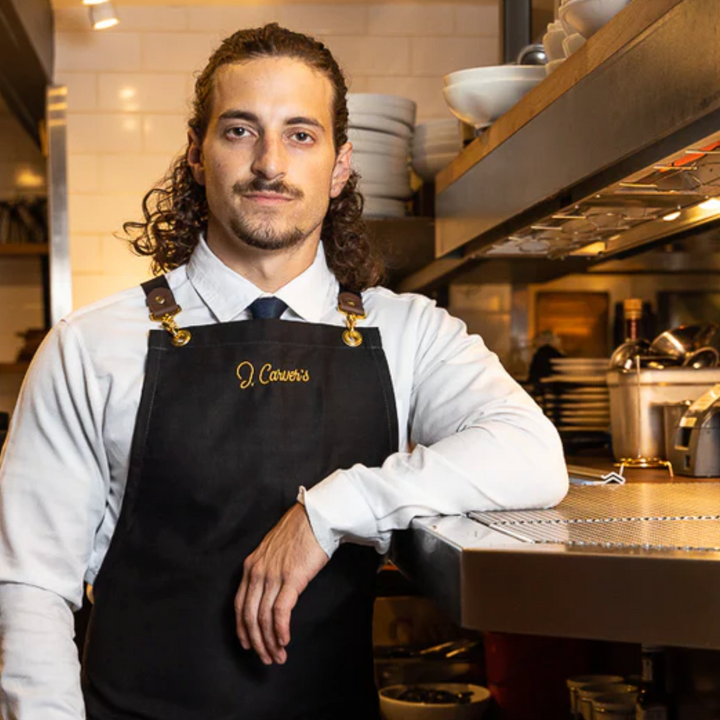 Man in the J Carver restaurant kitchen wearing custom Savilino apron