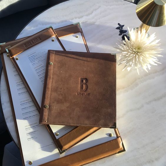 Custom Savilino leather menus and wine list at a restaurant table